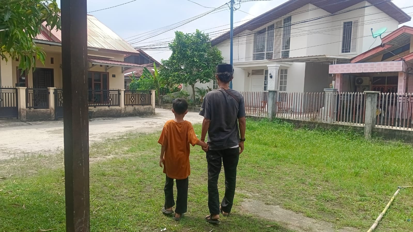 Seorang ayah menggandeng anaknya menuju masjid untuk menunaikan Shalat Jumat di Kota Dumai.
