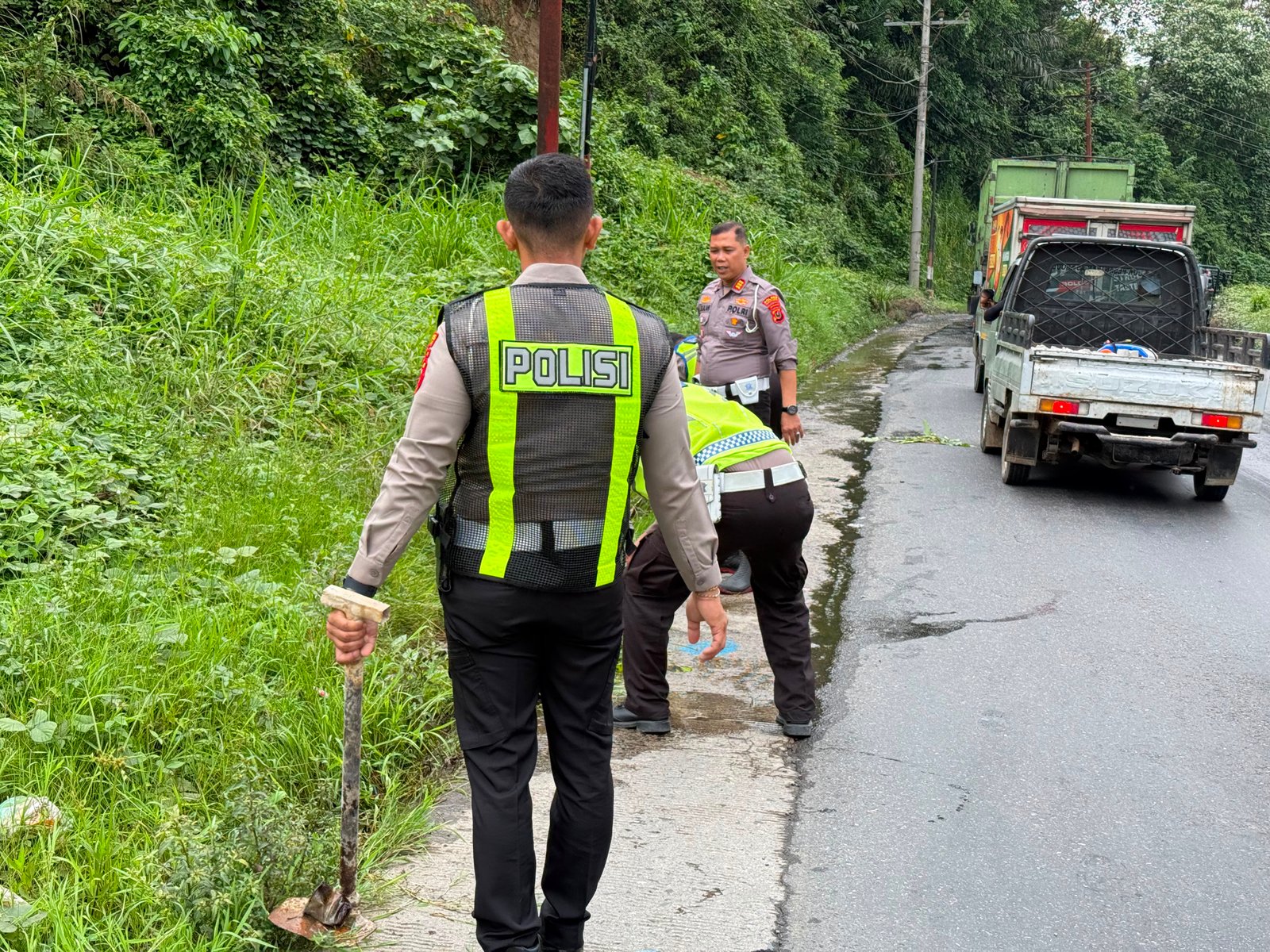 Satlantas Polres Padangsidimpuan membersihkan drainase di Jalan Lintas Sumatera.
