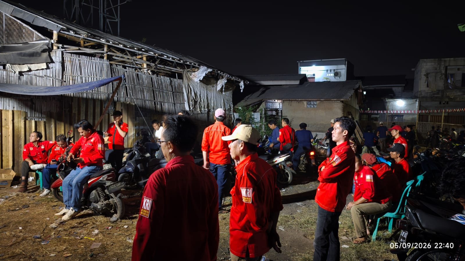 Kegiatan masyarakat di malam hari bersama anggota organisasi berbaju merah